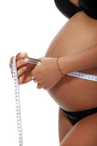 Midsection of woman holding hands against white background