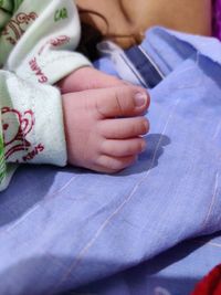 Close-up of baby hand on bed