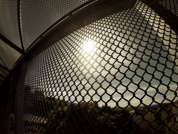 Sun shining through chainlink fence