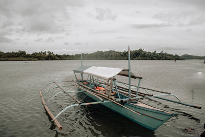 Boat moored in sea against sky