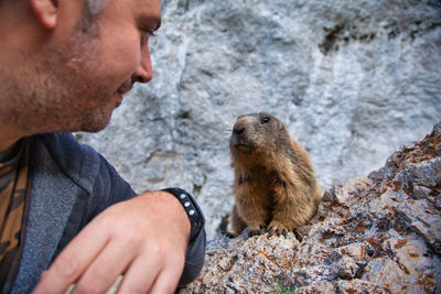 Side view of man looking at rock