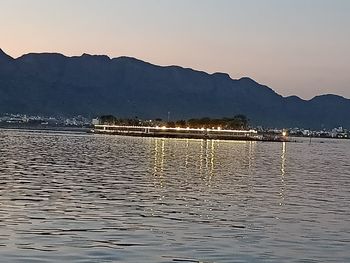 Scenic view of lake against clear sky during sunset