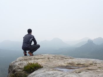 Rear view of man looking at mountain against sky