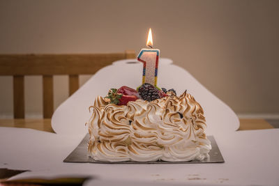 Illuminated candle on birthday cake