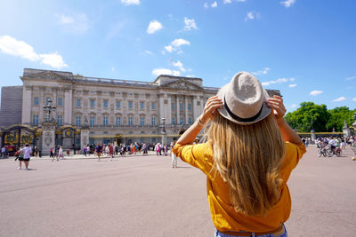 Back view of young tourist woman visiting london, united kingdom