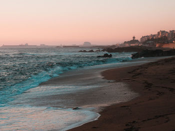 Scenic view of beach against clear sky during sunset