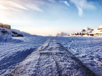 Surface level of snow covered landscape against sky