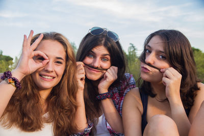 Portrait of smiling young women enjoying against sky