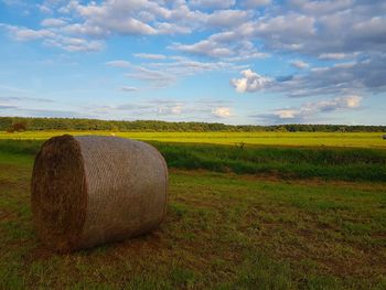 Hay bales on field against sky