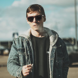 Portrait of young man wearing sunglasses standing outdoors