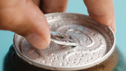 Hand opens can of beer