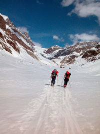 People skiing on snowcapped mountain during winter