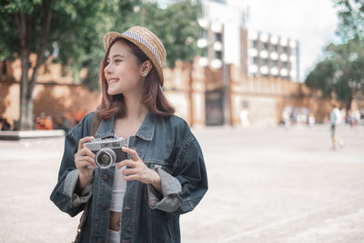 Portrait of young woman photographing