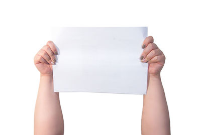 Close-up of hand holding paper against white background