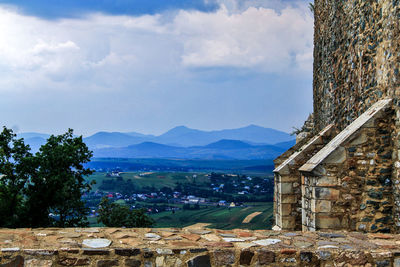 Scenic view of old castle wall and mountains against sky