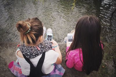 Rear view of women using mobile phones