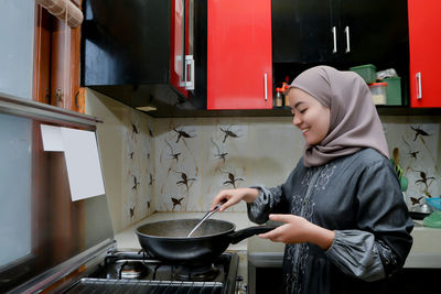 Portrait of young woman in kitchen