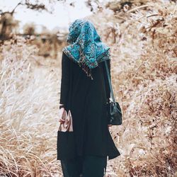 Rear view of woman walking on field