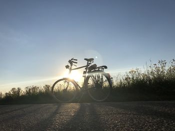 Man riding bicycle on road against sky