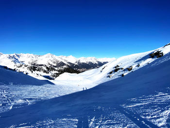 Scenic view of snowcapped mountains against clear blue sky