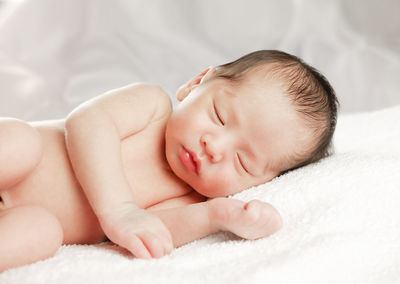 Baby boy sleeping on bed