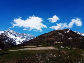 Scenic view of snowcapped mountains against blue sky