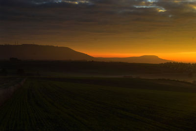 Scenic view of field against sky during sunset