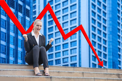 Woman with umbrella against buildings in city