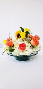 Various flowers on table against white background