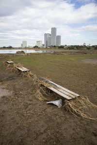 Scenic view of land and buildings in city against sky