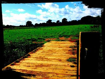 Scenic view of grassy field against cloudy sky