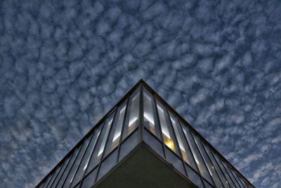 Low angle view of modern building against cloudy sky