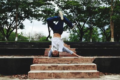 Man practicing stunt on steps in park