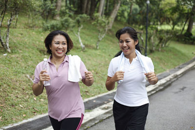 Portrait of a smiling young woman drinking water