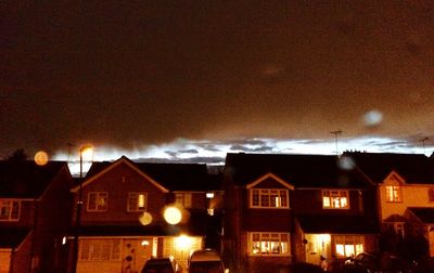 Illuminated buildings against sky at night