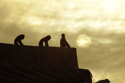 Low angle view of silhouette statue against sky during sunset