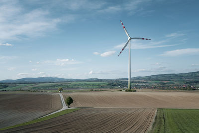 Windmill on field against sky