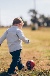 Boy playing with ball in park