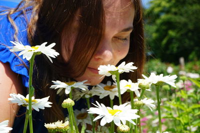 Close-up of woman against white flowering plants