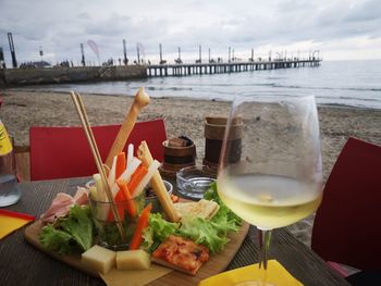 Food on table by sea against sky