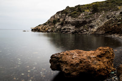 Rock formation on sea against sky