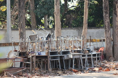 Abandoned shopping cart on table against trees