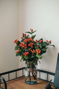 Close-up of flower vase on table against wall at home