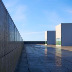 View of footpath by building against sky