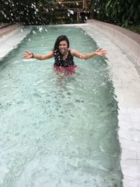 Portrait of smiling young woman in swimming pool