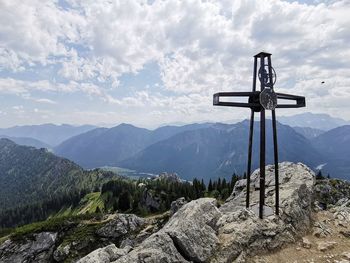 View of cross on mountains against sky