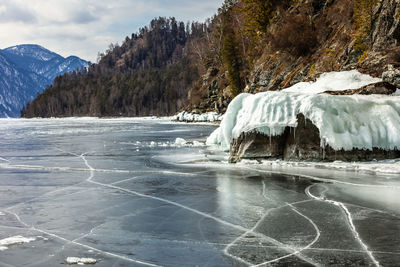 View of beautiful drawings on ice from cracks on the surface of lake teletskoye in winter, russia