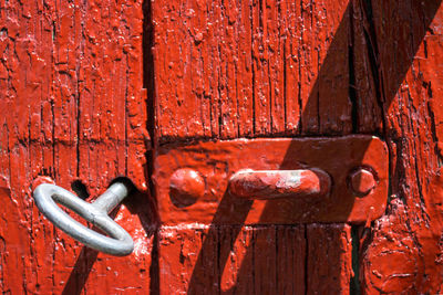 Antique iron key from the gate in the old red wooden gate.