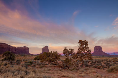 Rock formations on landscape against sky during sunset