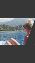 Woman looking at sea against mountain